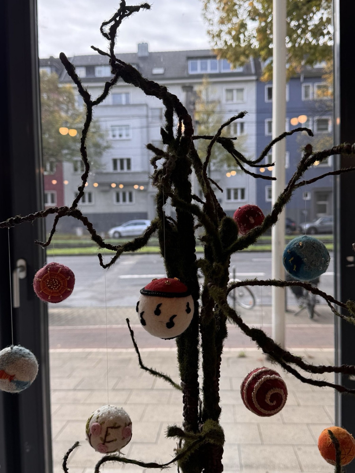 Bestickte Wunschkugeln aus Filz in den Zweigen des Wunschbaums